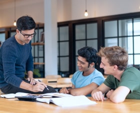 serious-teacher-checking-assignment-two-students